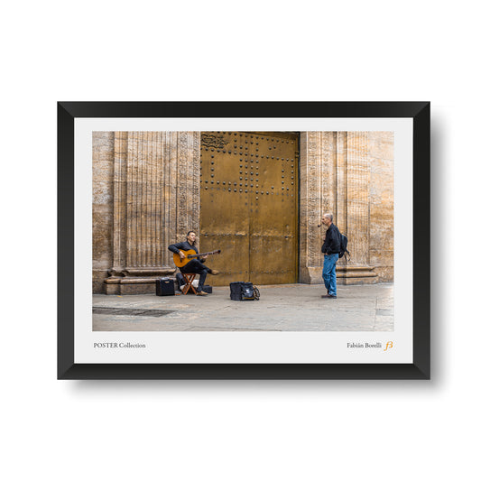 Músico callejero tocando guitarra frente a una puerta dorada en un entorno urbano, fotografía de autor de Fabián Borelli.